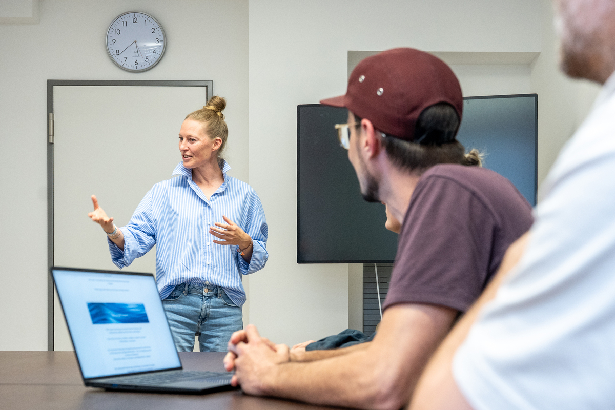Personen im Gespräch an einem Schreibtisch