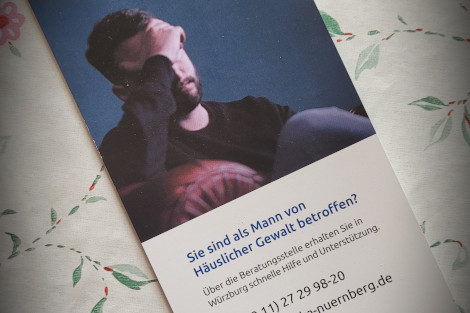 Der Flyer der Beratungsstelle liegt auf einer geblümten Tischdecke