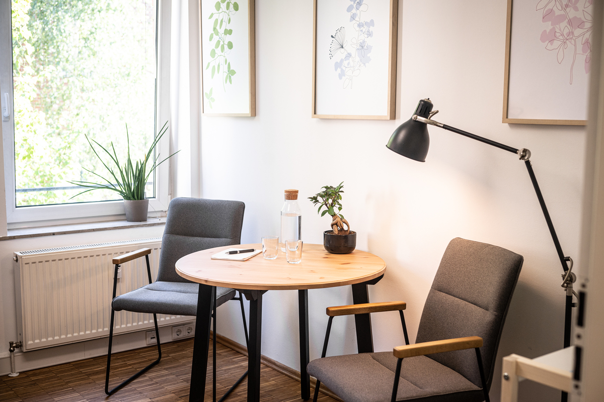 Eine Sitzecke mit Tisch und zwei Stühlen an einem Fenster