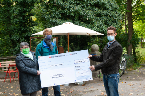 Drei Personen bei Übergabe der Spende am Friedhofscafe