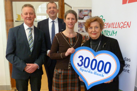 Mitarbeiterinnen, ein Angestellter der Sparda Bank und OB Jung bei der Übergabe der Spende