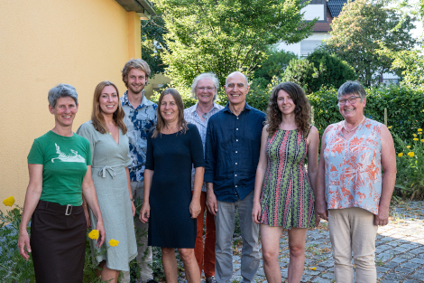 In einem begrünten Hof im Sonnenschein stehen nebeneinander die hauptamtlichen Mitarbeiter/innen vom Freiwilligen-Zentrum Fürth