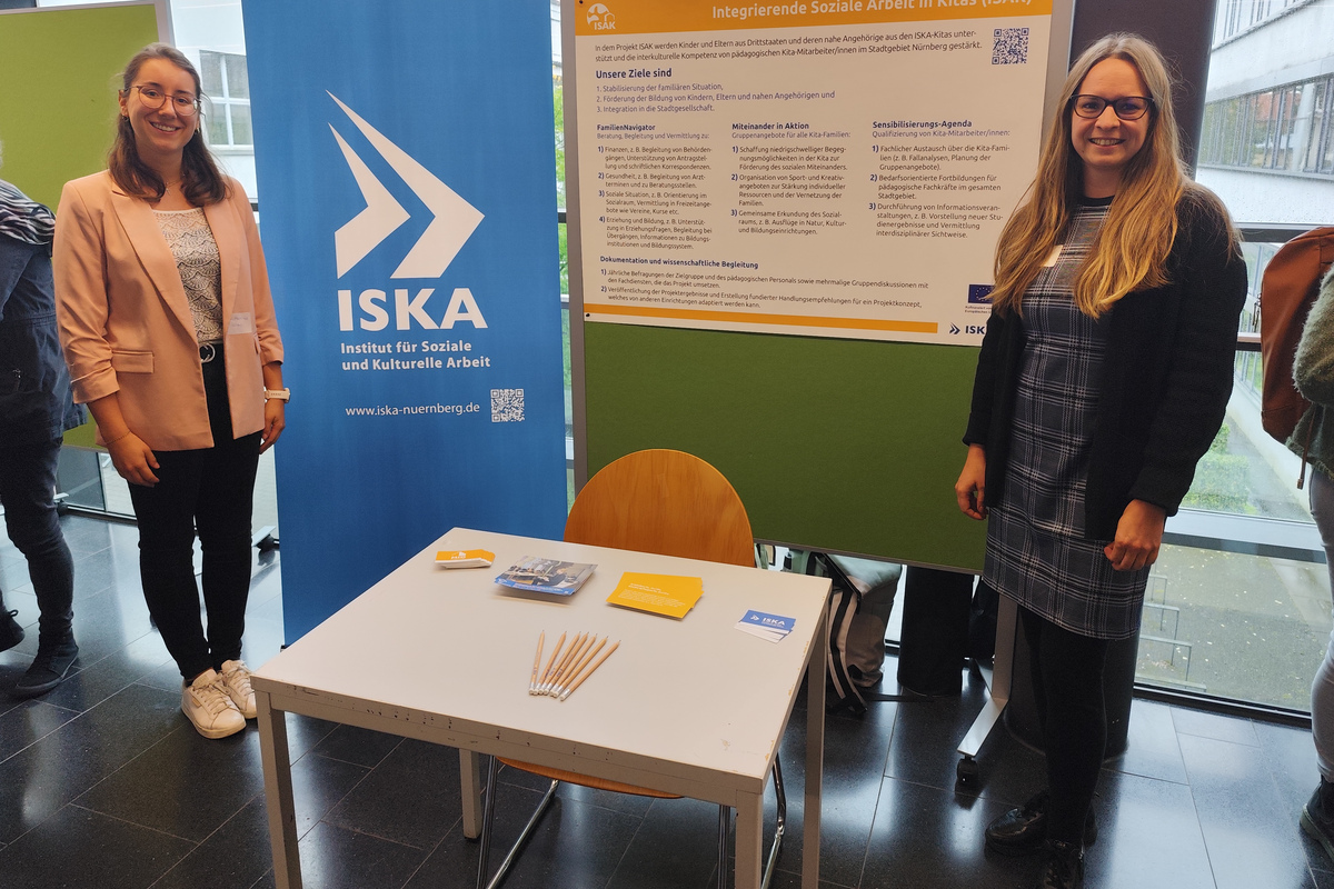 Zwei Frauen stehen vor einem Roll Up und einem ISAK Poster