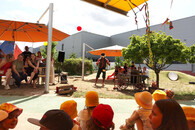 Ein Clown steht im Garten und spielt Diabolo vor Publikum.