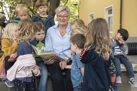 Ehrenamtliche beim Vorlesen im Hof