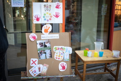 Auf einem Aufsteller sind verschiedene Plakate mit bunten Bildern und Texten