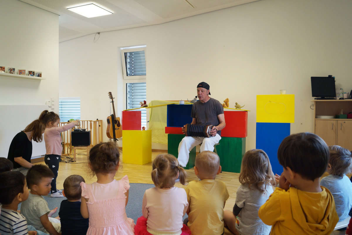 Der Schauspieler macht mit den Kindern Musik.