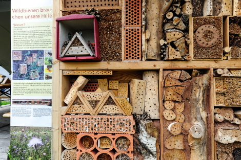 Detailaufnahme eines Insektenhotels mit vielen verschiedenen Materialien mit Schlupflöchern.
