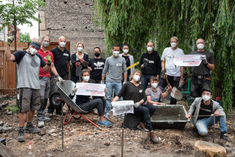 Gruppenfoto, bei dem viele Freiwillige Werkzeuge in den Händen halten