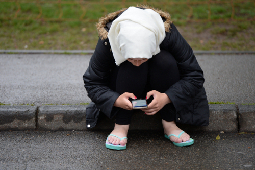 Junge Flüchtlingsfrau mit Smartphone