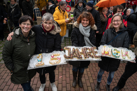 Vier Frauen präsentieren auf Tabletts einen gebackenen Schritzug: 15 Jahre MGH