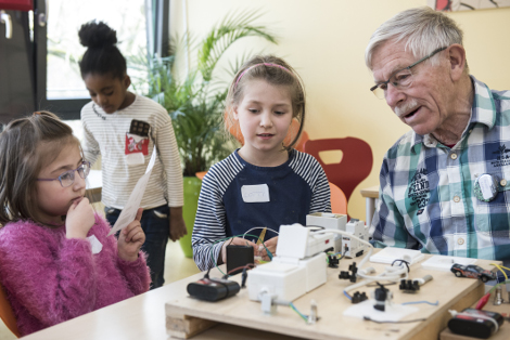 Ehrenamtlicher beim experimentieren mit Kindern