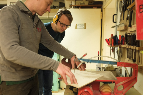 Ehrenamtliche in Werkstatt bei der Arbeit mit Stichsäge