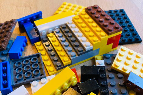 Eine kleine Rampe aus Lego, daneben einzelne Legosteine