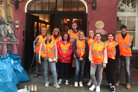 Eine Gruppe Müllsammler hat sich in orangenen Warnwesten vor dem Casablanca-Kino mit 7 Müllsäcken zum Groppenfoto versammelt.