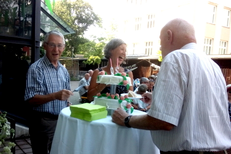 Ehren- und Hauptamtliche schneiden den Jubiläums-Kuchen an