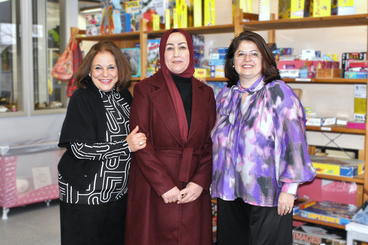 Drei ehrenamtliche Mitarbeiterinnen vor dem Regal mit Spielen in der Spendenausgabe der Noris-Arbeit im Südstadtforum in Nürnberg.